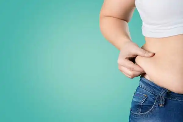 Image of woman pinching her love handles to show weight gain Greenock
